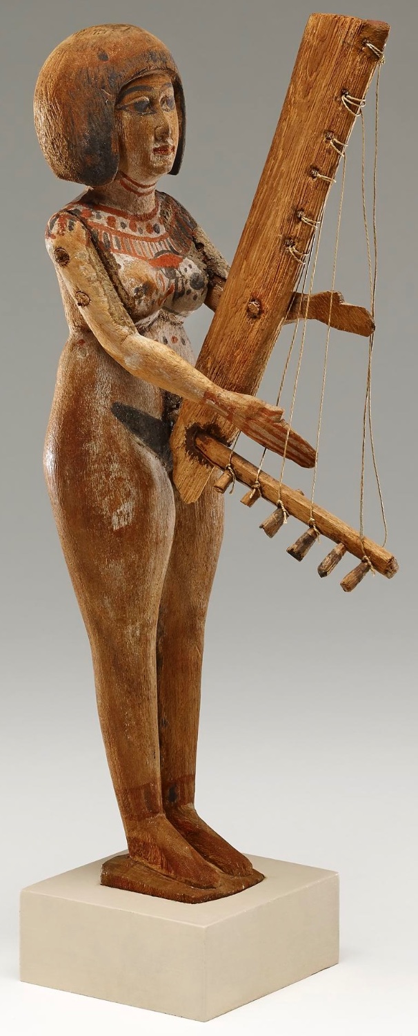 Solve Painted wooden figure of a woman playing a small angular harp ...