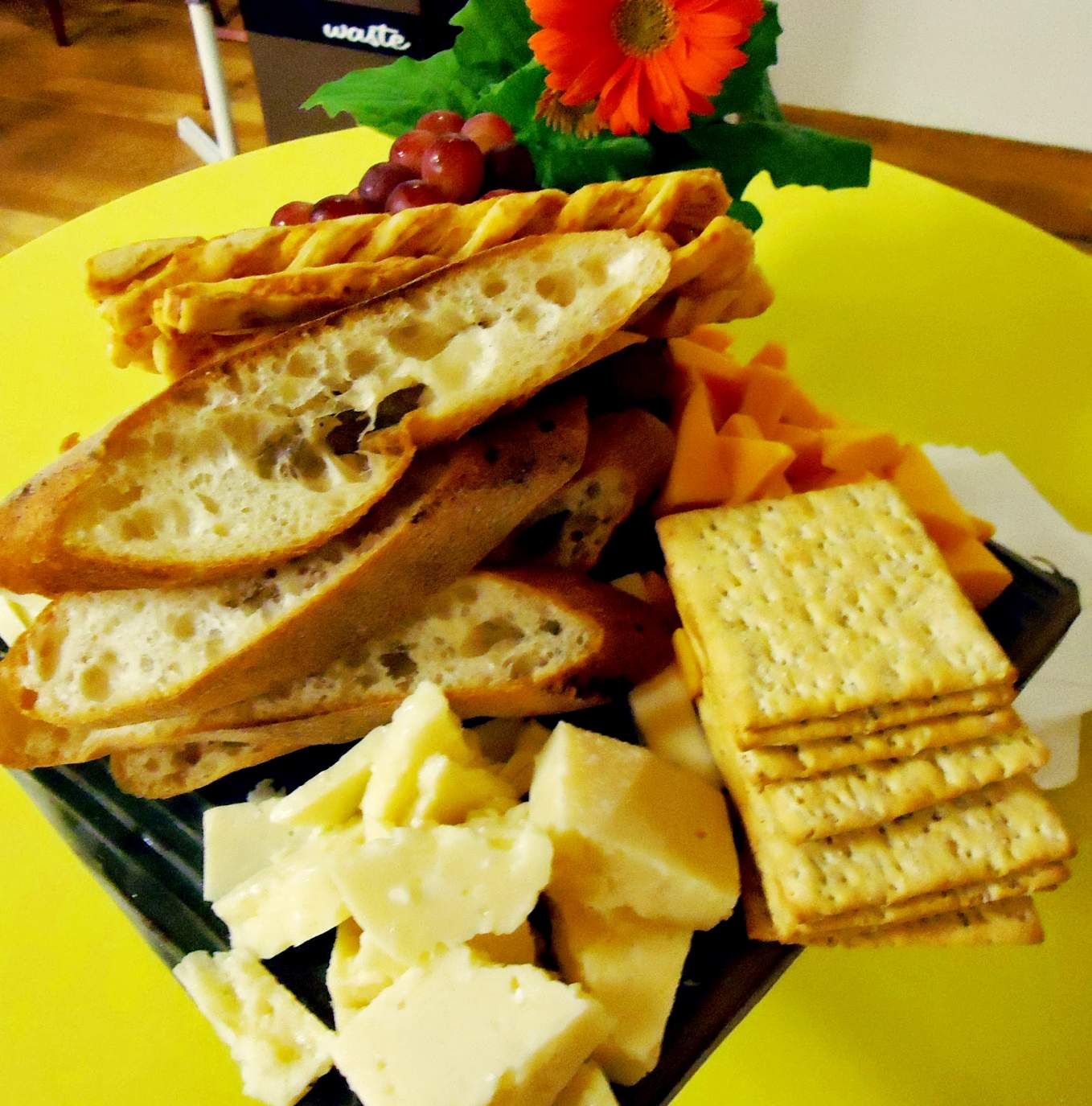 Solve pCheese_and_crackers_with_a_flower_on_a_table_with_a_yellow